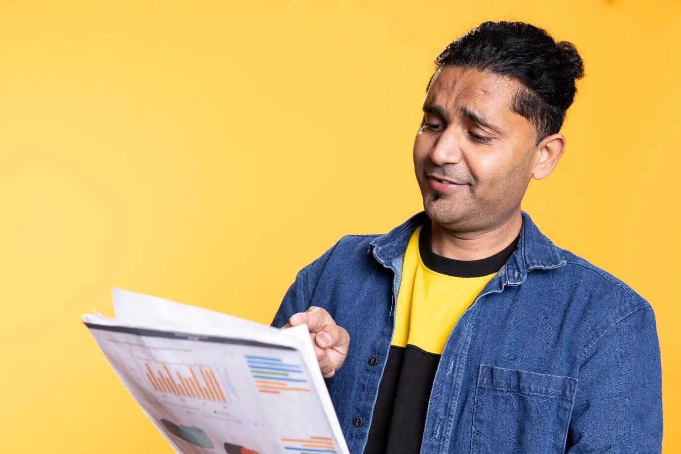 Молодой индиец просматривает бумаги отчета по финансовому аудиту.