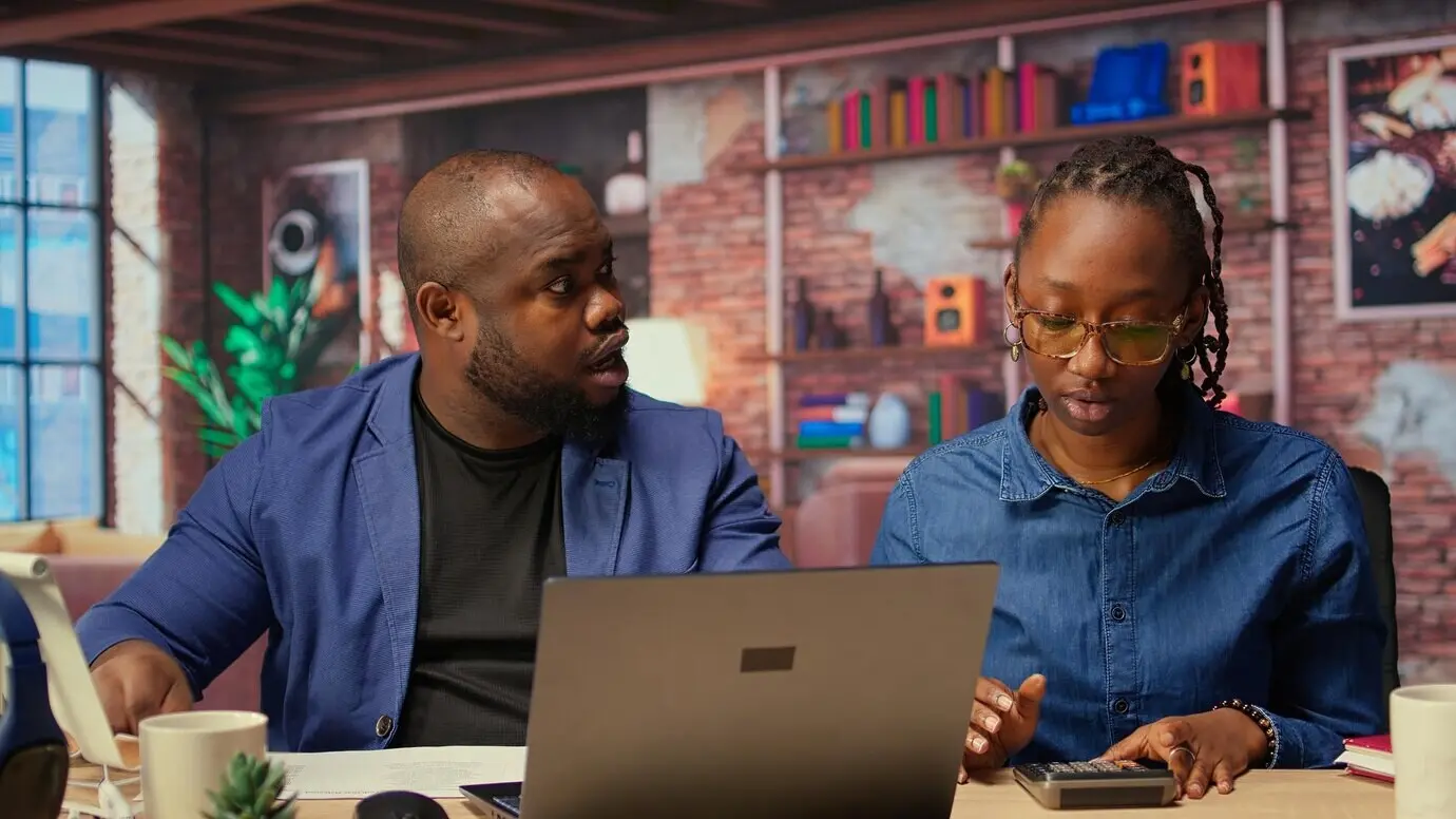 Афроамериканская пара дома обсуждает платежи по ипотеке и страховке.